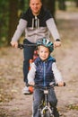 Parents and kids cycling on forest trail. family in warm clothes cycling autumn park. Family mountain bike on forest. active Royalty Free Stock Photo