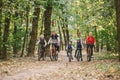 Parents and kids cycling on forest trail. Young family cycling in autumn park. Family mountain biking on forest. Theme family Royalty Free Stock Photo