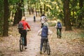 Parents and kids cycling on forest trail. Young family cycling in autumn park. Family mountain biking on forest. Theme family Royalty Free Stock Photo