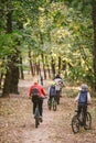 Parents and kids cycling on forest trail. Young family cycling in autumn park. Family mountain biking on forest. Theme family Royalty Free Stock Photo