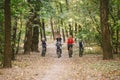 Parents and kids cycling on forest trail. Young family cycling in autumn park. Family mountain biking on forest. Theme family Royalty Free Stock Photo