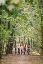 Parents and kids cycling on forest trail. Young family cycling in autumn park. Family mountain biking on forest. Theme family Royalty Free Stock Photo