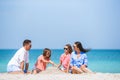 Parents and kids making sand castle at tropical beach. Family playing with beach toys Royalty Free Stock Photo