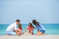 Family of parents and kids playing with sand on tropical beach Royalty Free Stock Photo