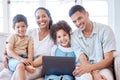 Parents, kids and portrait on sofa with laptop, smile and together for movie, video or cartoon on web. Young family Royalty Free Stock Photo