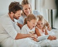 Parents, kids and tablet learning in bedroom, games and watching cartoons on internet, online and relax at home. Happy Royalty Free Stock Photo
