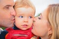 Parents kiss child outdoors Royalty Free Stock Photo