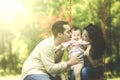 Parents kiss their child on swing Royalty Free Stock Photo
