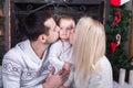 Parents kissing cute funny child