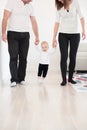 Parents learning their beautiful baby girl how to walk. Royalty Free Stock Photo