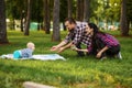 Parents and little baby play on grass in park