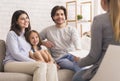 Parents With Little Daughter Sitting At Psycholigist`s Office After Successful Therapy