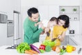 Parents and little girl making salad