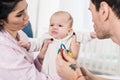 Parents looking at emotional baby in hands