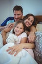 Parents lying on bed with daughter Royalty Free Stock Photo