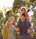 Parents, nature and carrying child outdoors, love and bonding on summer holiday or vacation. Happy family, shoulders and Royalty Free Stock Photo