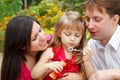 Parents observe as daughter blows soap bubble