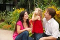 Parents observe as daughter blows soap bubbles