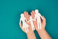 Parents with one child holding hands, paper cut out, copy space, petrol colored background Royalty Free Stock Photo