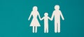 Parents with one child holding hands, paper cut out, copy space, petrol colored background Royalty Free Stock Photo