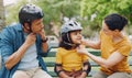 Parents, park bench and helmet with child, helping hand and safety for skating, rollerskate or bike. Interracial parents