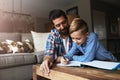 Parents play an active role in a childs educational upbringing. a father helping his little son with his homework.