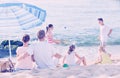Parents and playing children on beach Royalty Free Stock Photo