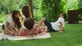 Parents playing with children in park. Kids and parents lying on blanket Royalty Free Stock Photo