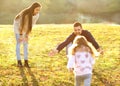 Parents playing with daughter in park at sunset Royalty Free Stock Photo