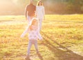 Parents playing with daughter in park at sunset Royalty Free Stock Photo