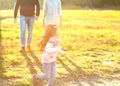 Parents playing with daughter in park at sunset Royalty Free Stock Photo