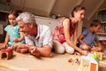 Parents playing with kids and toys in an attic playroom Royalty Free Stock Photo