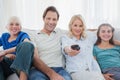 Parents posing with children and watching television