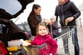 Parents pushing shopping cart with groceries and their daughters Royalty Free Stock Photo