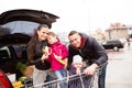 Parents pushing shopping cart with groceries and their daughters Royalty Free Stock Photo