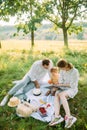 Parents read a book to their daughter in the park