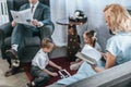 parents reading book an newspaper while happy kids playing with domino tiles