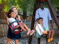 Parents riding children on swings