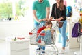 Parents riding their child in shopping trolley
