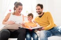 Parents showing their firstborn son pictures in family album