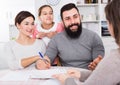 Parents signing property papers Royalty Free Stock Photo