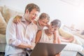 Parents sitting onthe floor with their children and using digital tablet in living room at home