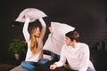 Parents with smiling child playing pillow fight on bed, happy family having fun in bedroom, enjoying leisure activity Royalty Free Stock Photo