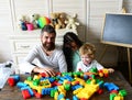 Parents and son with happy faces make brick constructions. Royalty Free Stock Photo