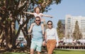 Parents with son walking in the city. Family taking a walk on street. Young couple walk in city park with son. Royalty Free Stock Photo