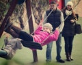 Parents swinging children at park