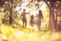 Parents swinging their daughter through the forest.