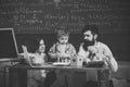 Parents teaches son, chalkboard on background. Boy listening to mom and dad with attention. Family cares about education Royalty Free Stock Photo