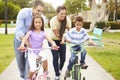 Parents Teaching Children To Ride Bikes In Park Royalty Free Stock Photo