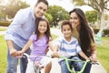 Parents Teaching Children To Ride Bikes In Park Royalty Free Stock Photo